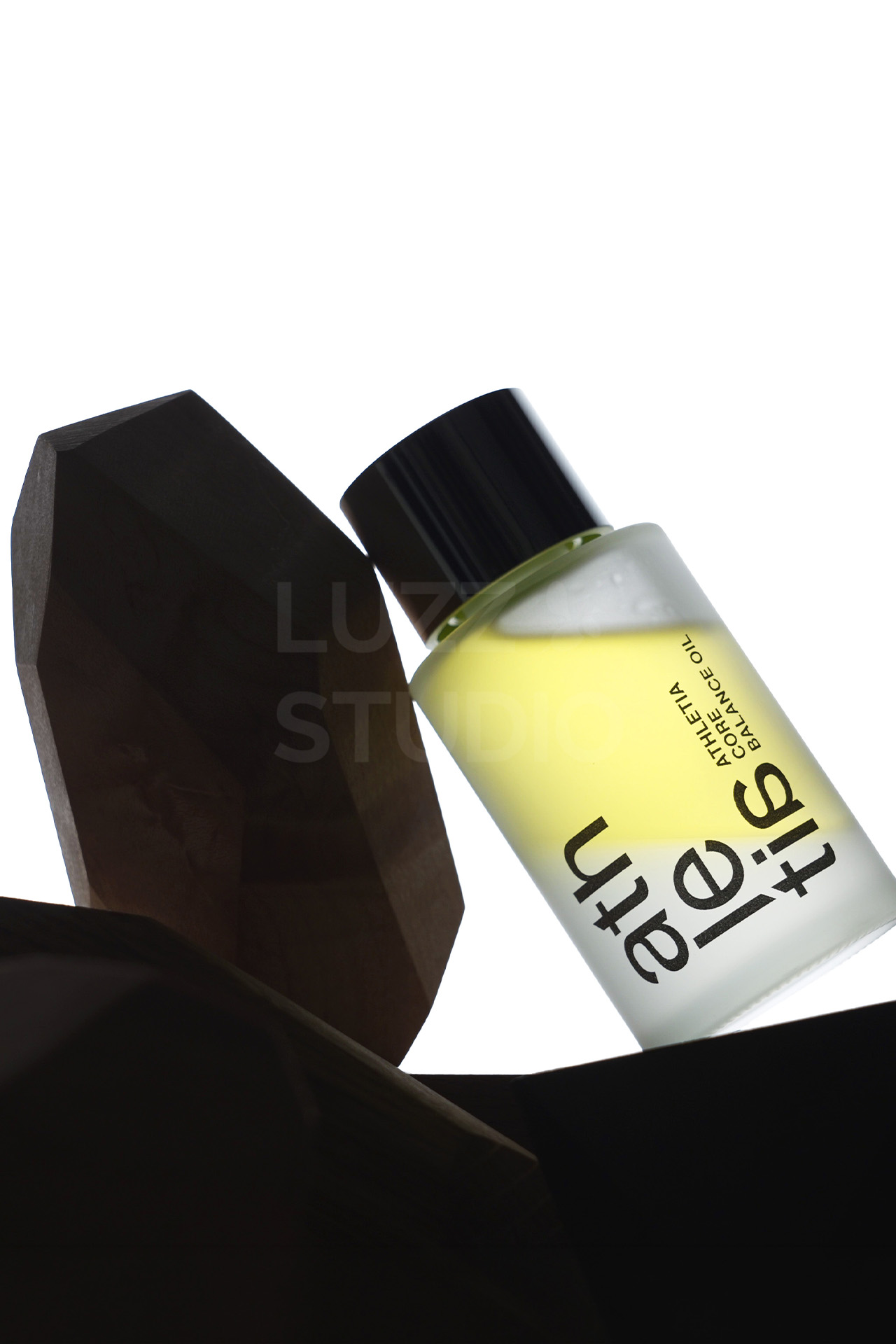 逆行ライティングでオイルの透明感と2層オイルのデザインを強調したスキンケア商品撮影