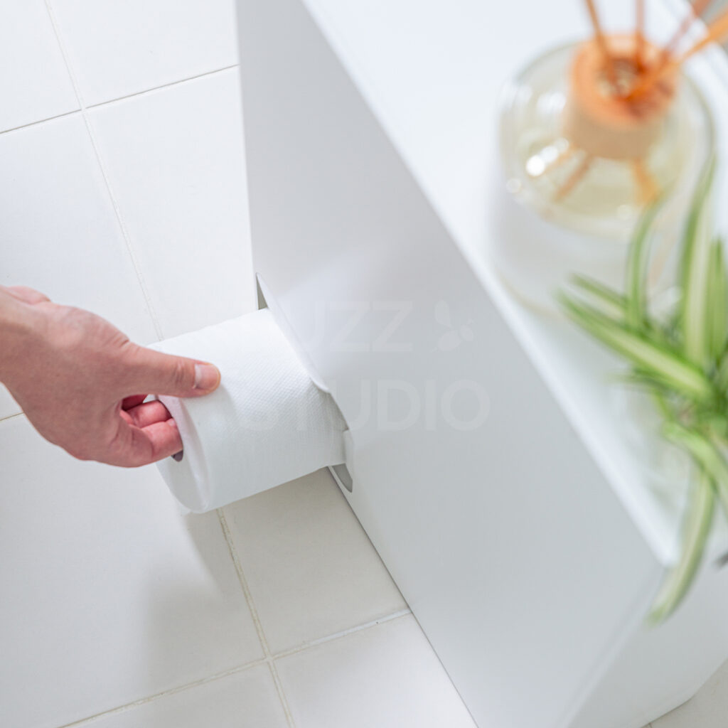 トイレットペーパーホルダーからトイレットペーパーを取り出している
