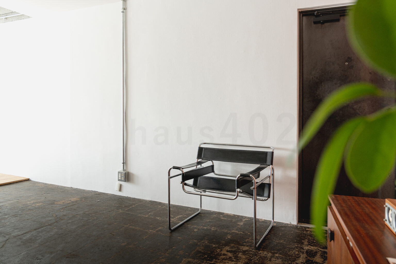 撮影代行会社・株式会社ラズスタジオが撮影依頼に対応する自社撮影スタジオ「haus405」の室内写真。ヴィンテージコンクリート床にラウンジチェアを配置した撮影スペース