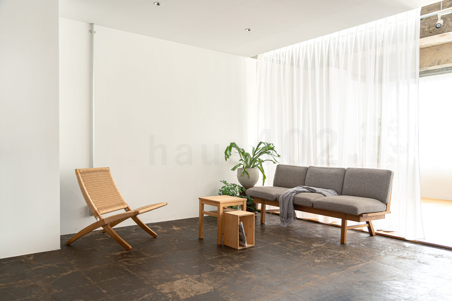 撮影代行会社・株式会社ラズスタジオが撮影依頼に対応する自社撮影スタジオ「haus403」の室内写真。自然光が差し込むレンタル撮影スタジオの内観。ラウンジチェアとソファを配置した、家具撮影やライフスタイル撮影に適した空間