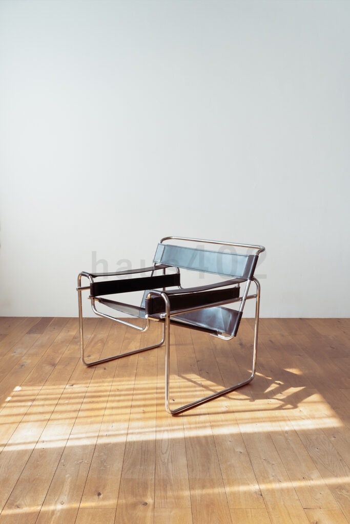 株式会社ラズスタジオの自社スタジオ「haus402」の無垢材床の空間で家具「ブラックラウンジチェア」を配置した写真