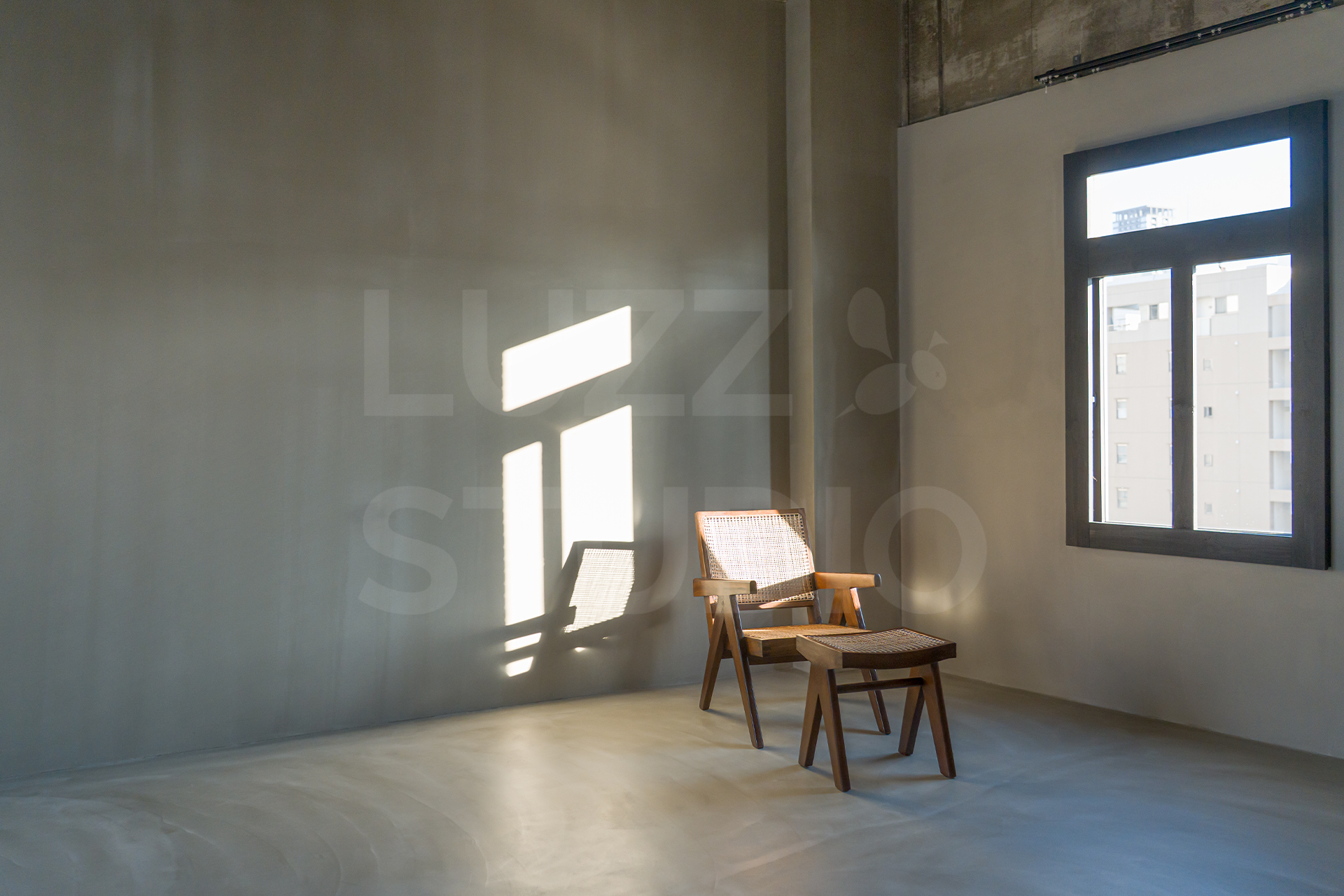 時間帯で表情を変える自然光が魅力の大阪のスタジオ。質感豊かなグレー背景とデザイナーズ家具を組み合わせた、ファッションやカタログ撮影に最適なスペース