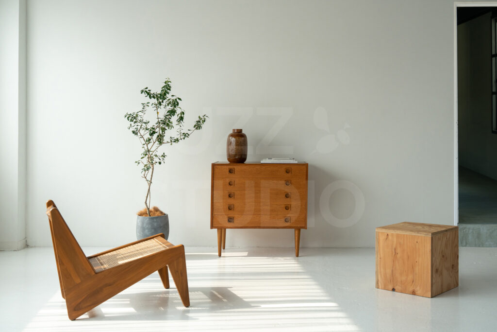 ブランドの世界観を引き立てる大阪の撮影スタジオ。清潔感のある白背景と温かみのある木製家具を組み合わせた、ポートレートや商品撮影に映えるセッティング