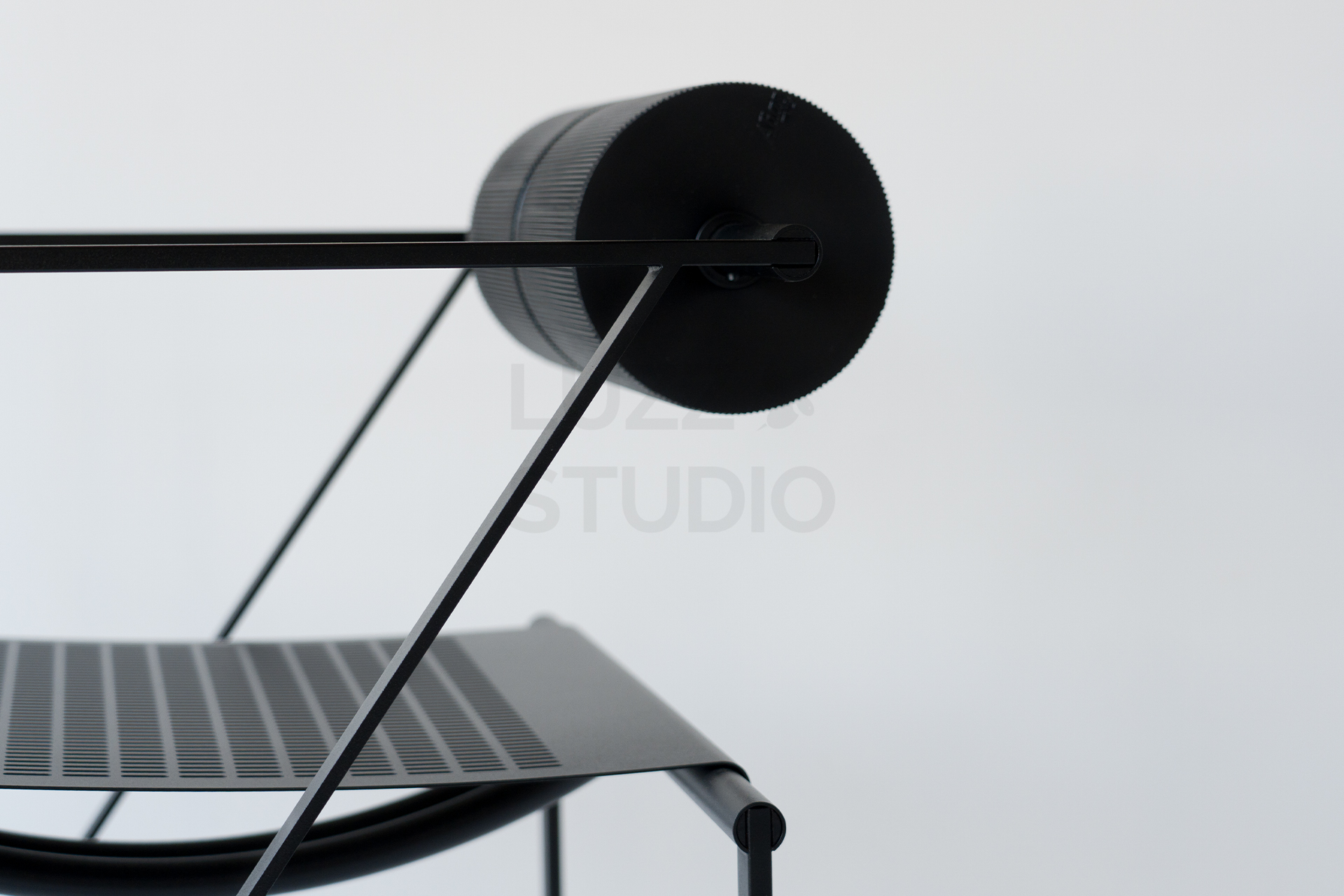 マリオ・ボッタ《Seconda Chair》の特徴である、円柱形の背もたれと格子状のスチールフレームのクローズアップ。建築的な美しさを放つ細部が、写真の質感を高める要素として機能する。