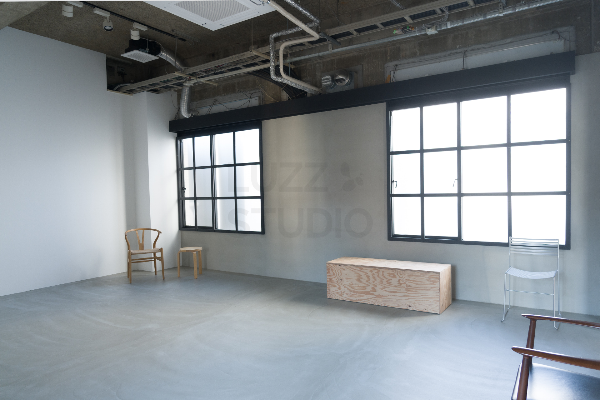 LUZZ STUDIO 堺筋本町の洗練された無機質なコンクリート質の壁面。ポストモダンデザインの家具を引き立てる、余白を活かしたミニマルかつモダンな撮影空間のディテール