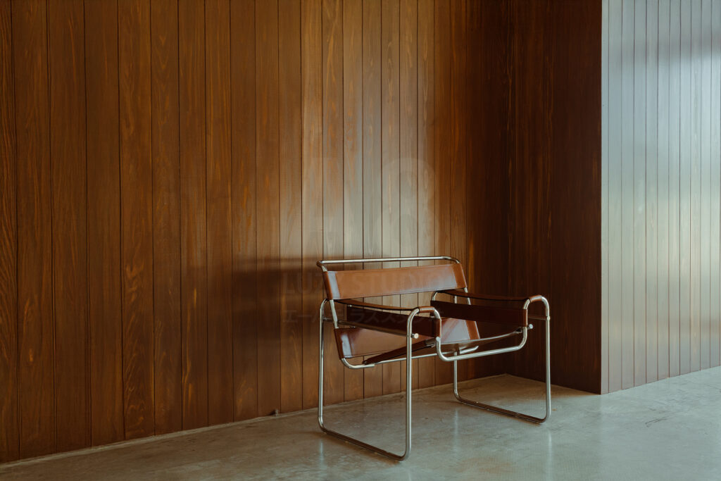スタジオ「A8 LUZZ STUDIO」のウッド壁の前にMarcelBreuer ワシリーチェアー ブラウンがおかれたスタジオ写真