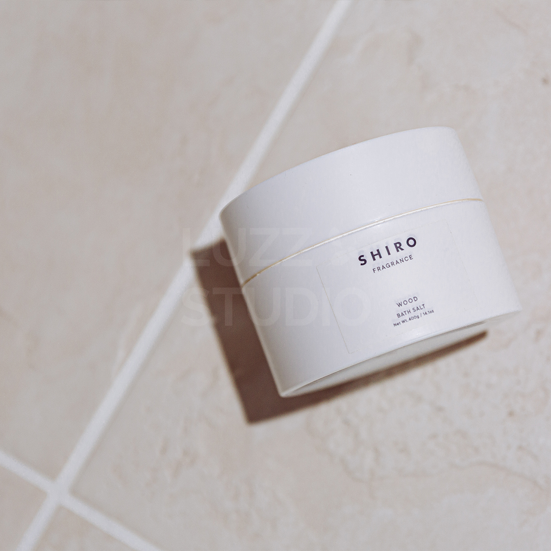 ピンクベージュの大理石タイルの上に置かれた入浴剤（バスソルト）のSNS用商品撮影写真