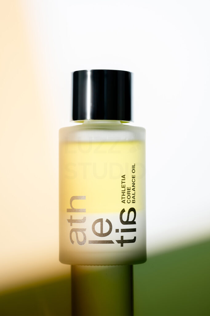 フロストガラスの質感を緻密なライティングで描き出した、スキンケアボトルの商品撮影。ブランドカラーを意識したライティングを用いたカタログ・ECサイト向けキービジュアル