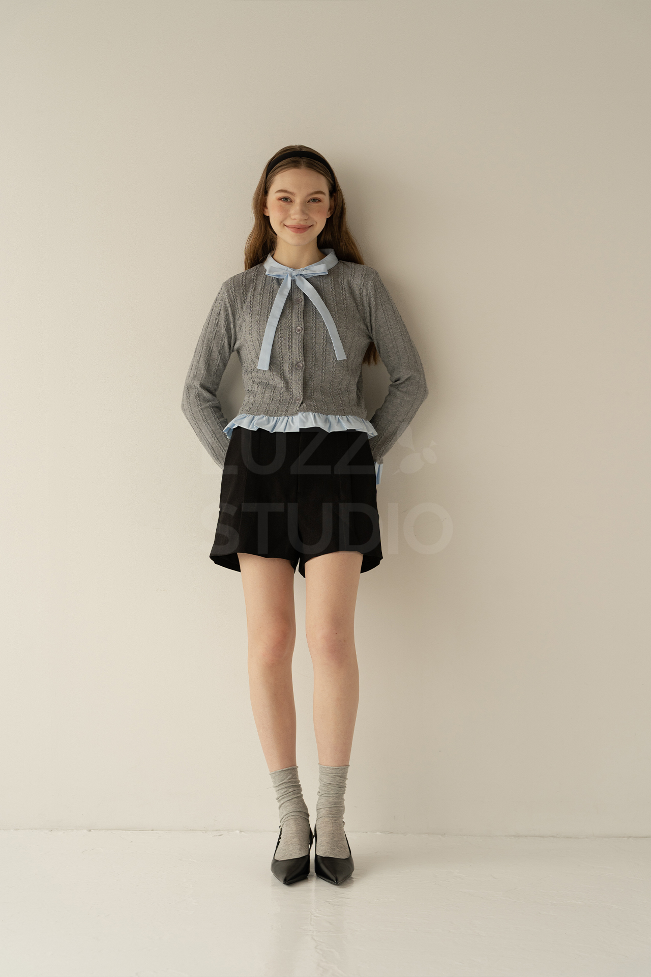 壁にもたれて笑顔のモデルのレディスアパレル商品撮影