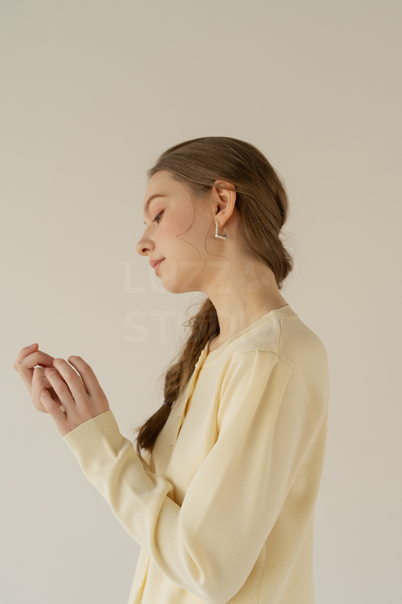 黄色のニットを心地よく着ている女性モデルによるアパレル商品撮影写真