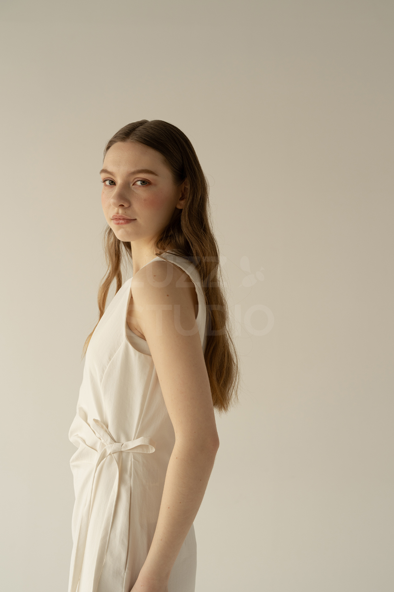 カメラ目線でほほ笑む女性モデルのアパレル商品撮影写真