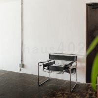 撮影代行会社・株式会社ラズスタジオが撮影依頼に対応する自社撮影スタジオ「haus405」の室内写真。ヴィンテージコンクリート床にラウンジチェアを配置した撮影スペース